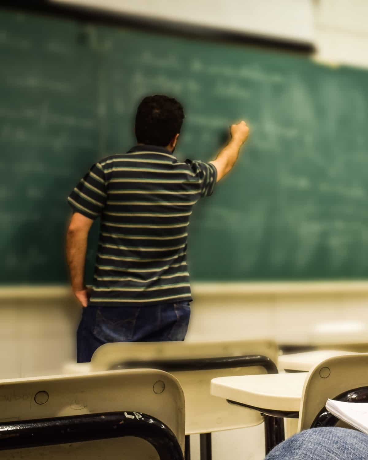 M. Srinivas at the blackboard, chalk in hand, working through a problem.