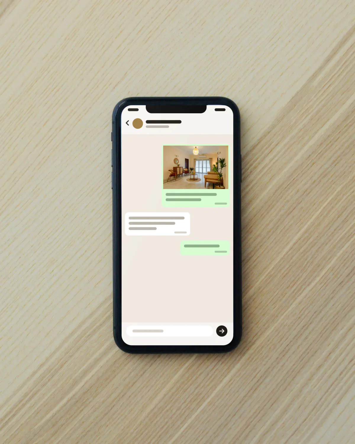 A phone showing a chat with a photograph of a room and a short message, the text too small to read.