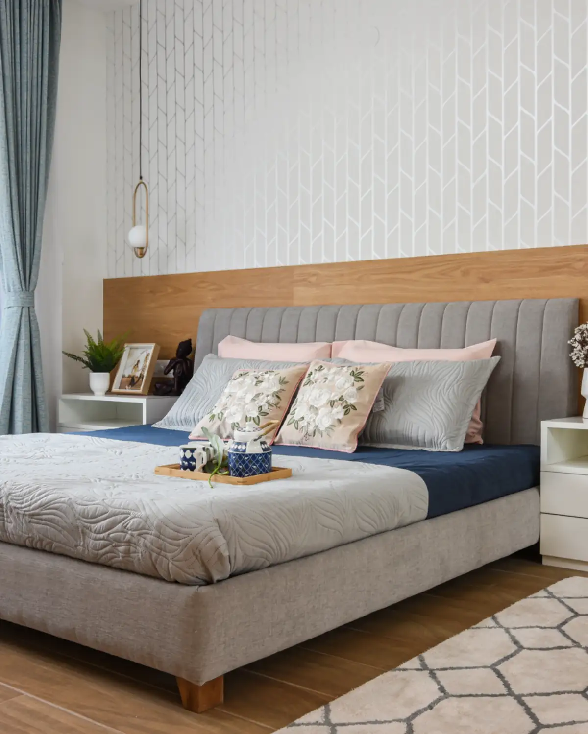 A bedroom set on the first floor, an upholstered bed against a teak headboard panel.