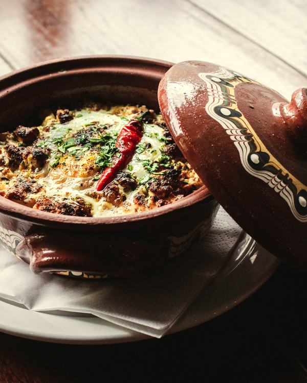 Mutton biryani in a clay pot, the painted lid set aside.
