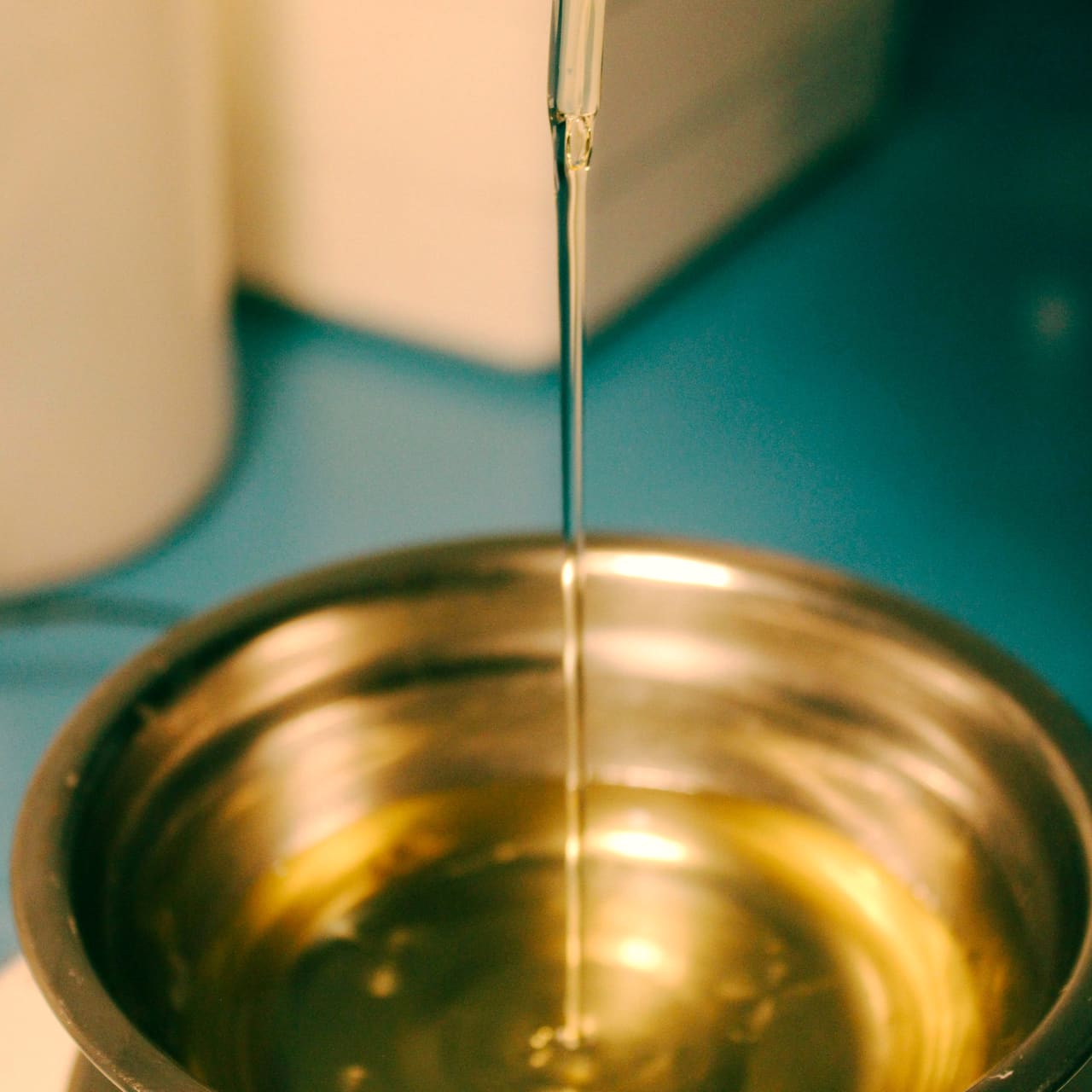 Warm oil poured into a brass bowl.