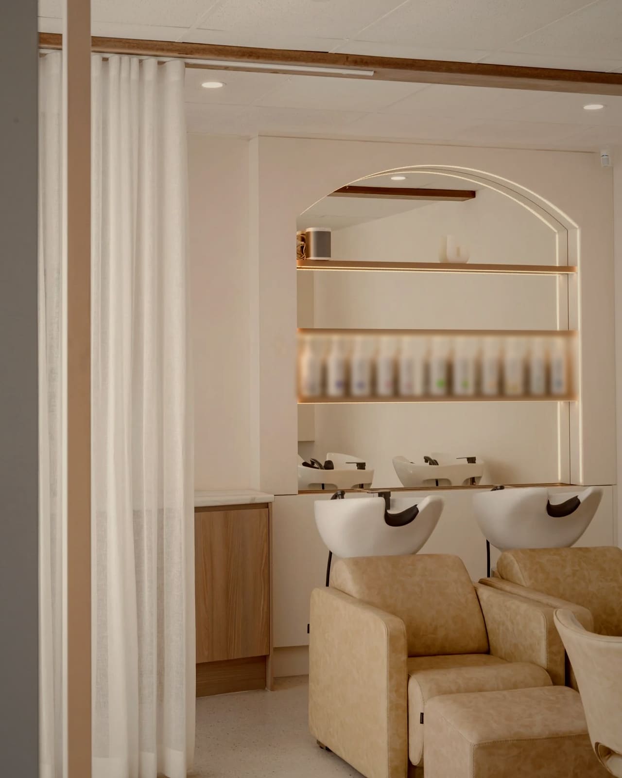 The far end of the floor: two wash chairs under a lit arched shelf, a linen curtain drawn aside.